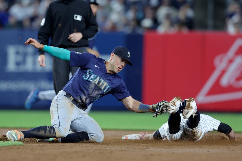 May 20, 2024; Bronx, New York, USA; New York Yankees third baseman Jon Berti (19) is tagged out trying to steal second base by Seattle Mariners shortstop Dylan Moore (25) during the eighth inning at Yankee Stadium. Mandatory Credit: Brad Penner-USA TODAY Sports