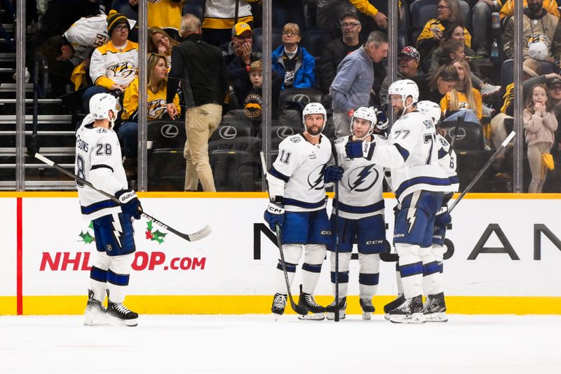 Nov 29, 2024; Nashville, Tennessee, USA;  Tampa Bay Lightning center Brayden Point (21) celebrates his game winning goal with his teammates against the Nashville Predators during the overtime period at Bridgestone Arena. Mandatory Credit: Steve Roberts-Imagn Images