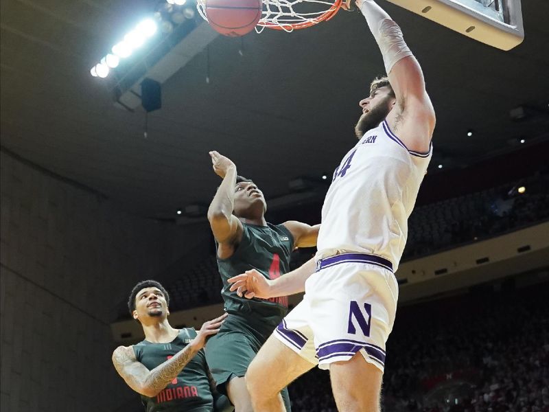 Feb 18, 2024; Bloomington, Indiana, USA;  Northwestern Wildcats center Matthew Nicholson (34) dunks the ball past Indiana Hoosiers forward Anthony Walker (4) during the second half at Simon Skjodt Assembly Hall. Mandatory Credit: Robert Goddin-USA TODAY Sports