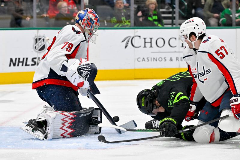 Jan 27, 2024; Dallas, Texas, USA; Dallas Stars center Roope Hintz (24) falls to the ice in between Washington Capitals goaltender Charlie Lindgren (79) and defenseman Trevor van Riemsdyk (57) during the second period at the American Airlines Center. Mandatory Credit: Jerome Miron-USA TODAY Sports