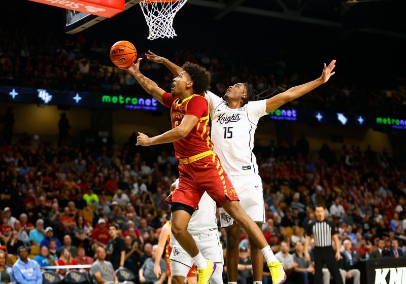 Feb 11, 2025; Orlando, Florida, USA;  Iowa State Cyclones guard Curtis Jones (5) lays the ball up while Central Florida Knights guard Tyler Hendricks (15) defends at Addition Financial Arena. Mandatory Credit: Russell Lansford-Imagn Images