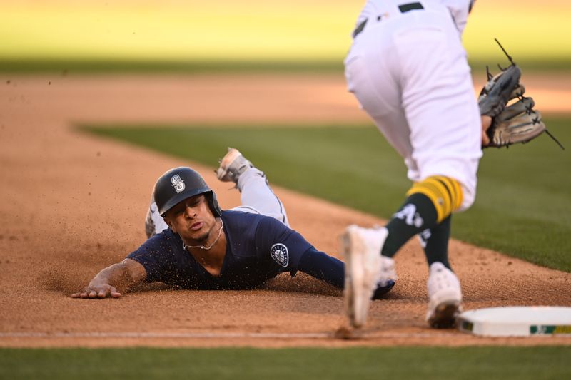 Sep 2, 2024; Oakland, California, USA; Seattle Mariners shortstop Leo Rivas (76) slides to steal third base against Oakland Athletics third base Tristan Gray (16) in the eighth inning at Oakland-Alameda County Coliseum. Mandatory Credit: Eakin Howard-USA TODAY Sports