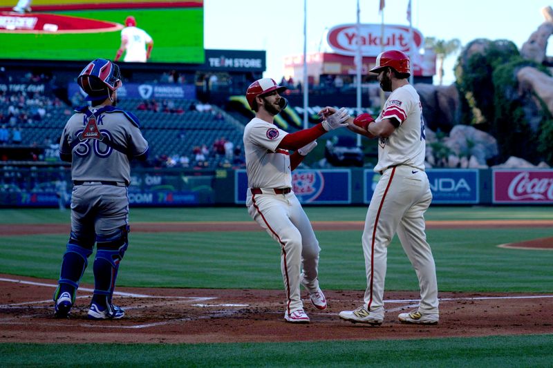 May 8, 2025; Anaheim, California, USA; Los Angeles Angels left fielder Taylor Ward (3) celebrates with first baseman Nolan Schanuel (18) after hitting a two-run home run in the first inning as Toronto Blue Jays catcher Alejandro Kirk (30) watches at Angel Stadium. Mandatory Credit: Kirby Lee-Imagn Images