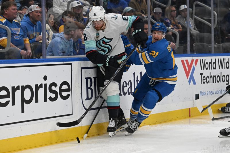 Nov 8, 2025; St. Louis, Missouri, USA; Seattle Kraken defenseman Adam Larsson (6) and St. Louis Blues right wing Jimmy Snuggerud (21) battle for the puck in the second period at Enterprise Center. Mandatory Credit: Joe Puetz-Imagn Images