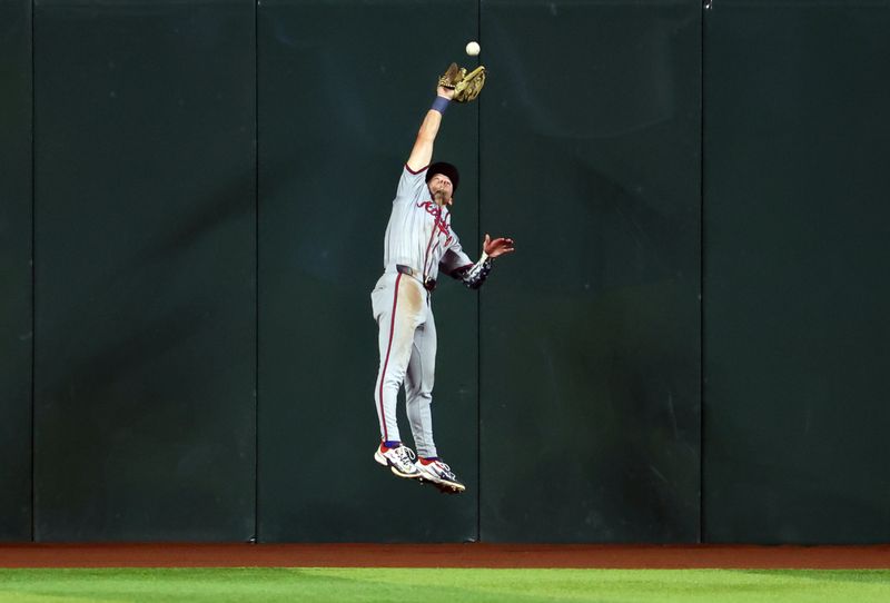 Jul 9, 2024; Phoenix, Arizona, USA; Atlanta Braves center fielder Jarred Kelenic makes a leaping catch at the wall in the seventh inning against the Arizona Diamondbacks at Chase Field. Mandatory Credit: Mark J. Rebilas-USA TODAY Sports