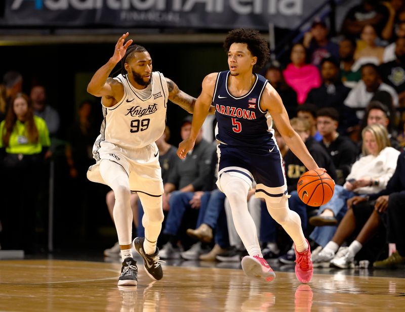 Jan 17, 2026; Orlando, Florida, USA;  Arizona Wildcats guard Brayden Burries (5) dribbles around Central Florida Knights forward Jordan Burks (99) in the first half at Addition Financial Arena. Mandatory Credit: Russell Lansford-Imagn Images