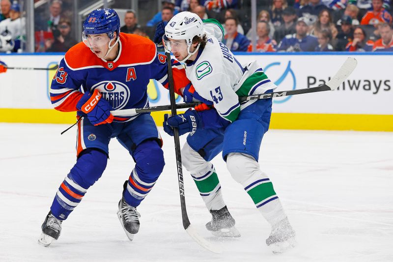 Apr 13, 2024; Edmonton, Alberta, CAN; Edmonton Oilers forward Ryan Nugent-Hopkins (93) and Vancouver Canucks defensemen Quinn Hughes (43) battles for position during the third period at Rogers Place. Mandatory Credit: Perry Nelson-USA TODAY Sports