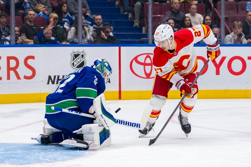 Nov 12, 2024; Vancouver, British Columbia, CAN; Vancouver Canucks goalie Kevin Lankinen (32) makes a save on Calgary Flames forward Matt Coronato (27) during the first period at Rogers Arena. Mandatory Credit: Bob Frid-Imagn Images