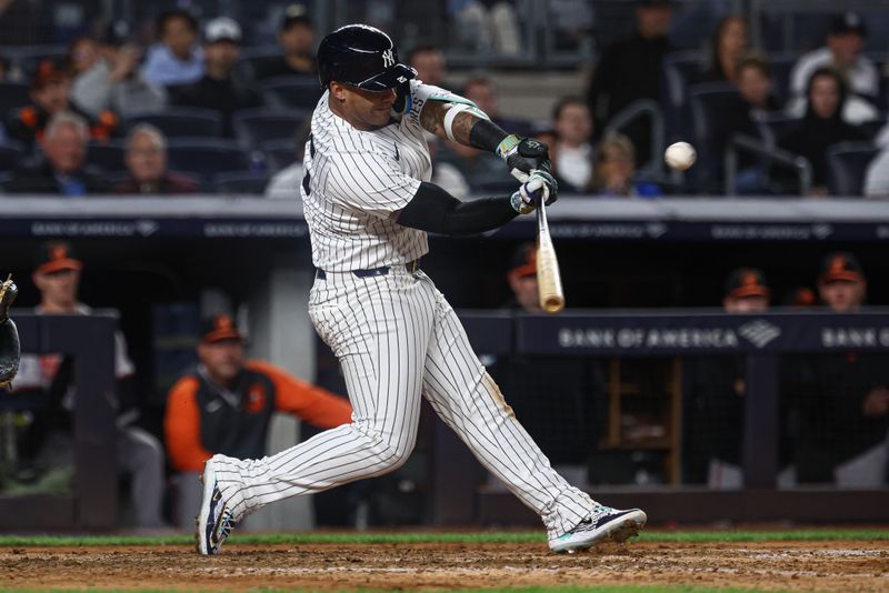 Sep 24, 2024; Bronx, New York, USA;  New York Yankees second baseman Gleyber Torres (25) hits a ground rule double during the seventh inning against the Baltimore Orioles at Yankee Stadium. Mandatory Credit: Vincent Carchietta-Imagn Images