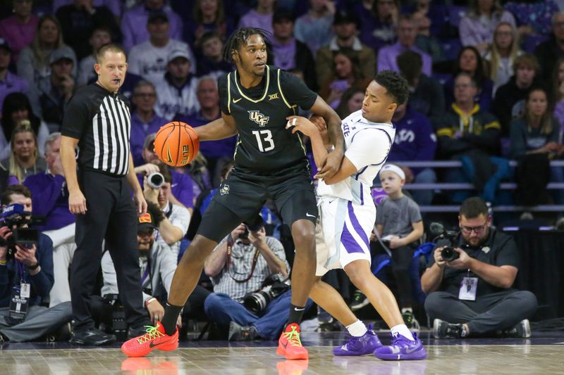 Jan 6, 2024; Manhattan, Kansas, USA; UCF Knights forward Marchelus Avery (13) is guarded by Kansas State Wildcats guard Tylor Perry (2) during the first half at Bramlage Coliseum. Mandatory Credit: Scott Sewell-USA TODAY Sports