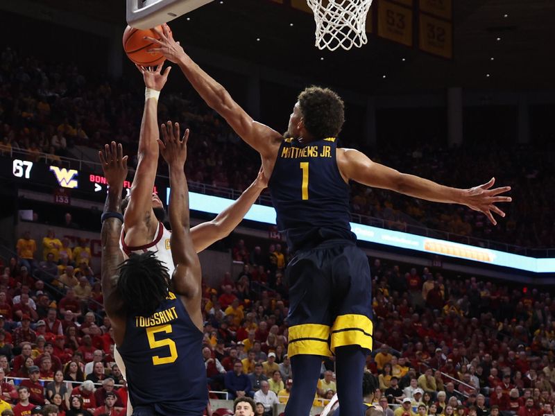 Feb 27, 2023; Ames, Iowa, USA; West Virginia Mountaineers forward Emmitt Matthews Jr. (1) blocks the shot from Iowa State Cyclones guard Jaren Holmes (13) during the second half at James H. Hilton Coliseum. Mandatory Credit: Reese Strickland-USA TODAY Sports