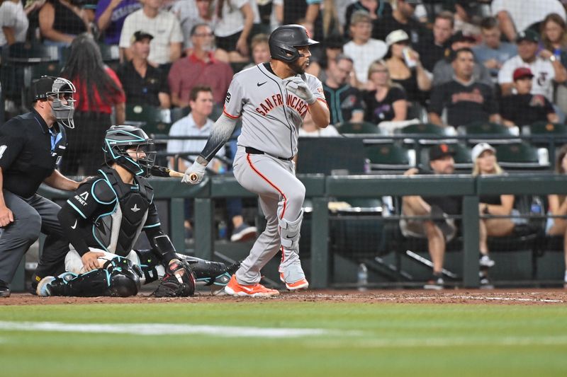 Jun 30, 2025; Phoenix, Arizona, USA;  San Francisco Giants first base Dominic Smith (7) doubles in the seventh inning against the Arizona Diamondbacks at Chase Field. Mandatory Credit: Matt Kartozian-Imagn Images