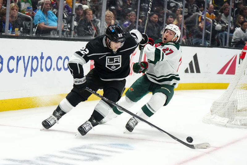 Apr 15, 2024; Los Angeles, California, USA; LA Kings left wing Kevin Fiala (22) and Minnesota Wild center Jacob Lucchini (27) battle for the puck in the third period at Crypto.com Arena. Mandatory Credit: Kirby Lee-USA TODAY Sports