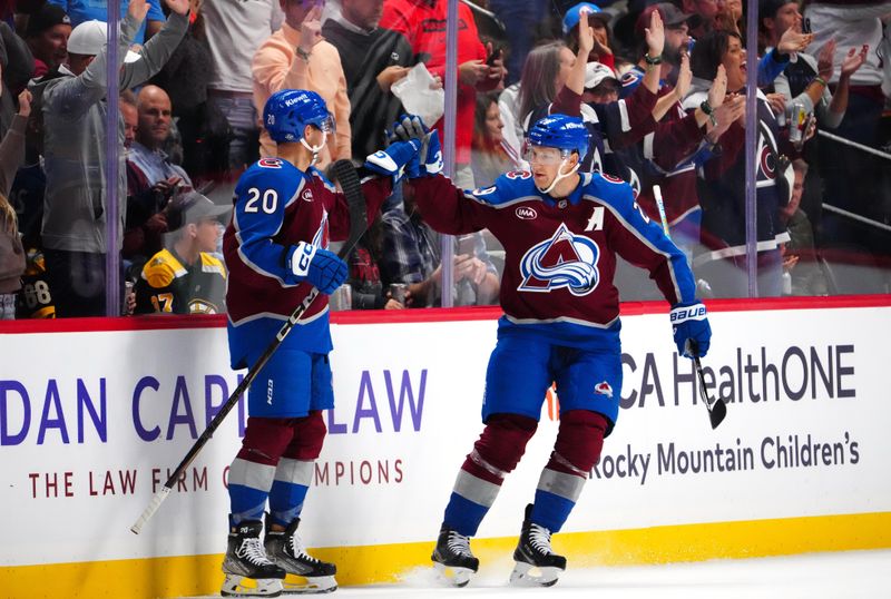 Oct 16, 2024; Denver, Colorado, USA; Colorado Avalanche center Ross Colton (20) celebrates his goal with center Nathan MacKinnon (29) in the first period against the Boston Bruins at Ball Arena. Mandatory Credit: Ron Chenoy-Imagn Images