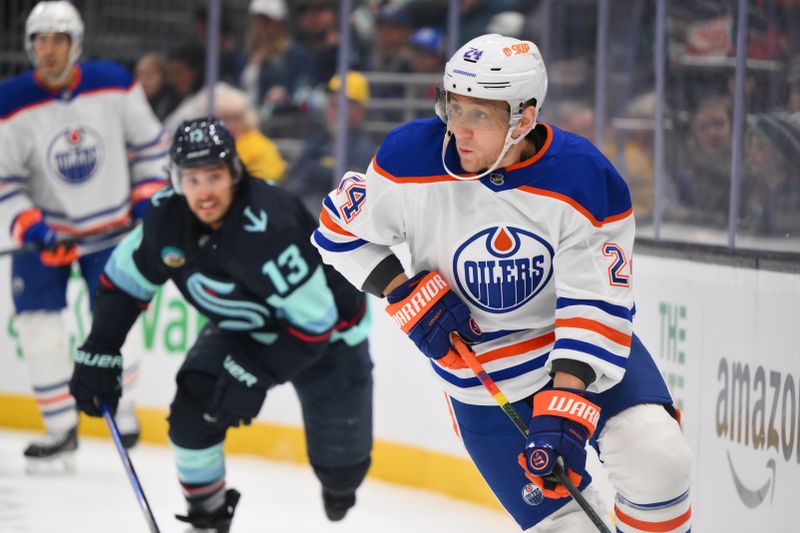 Oct 2, 2024; Seattle, Washington, USA; Edmonton Oilers defenseman Travis Dermott (24) advances the puck against the Seattle Kraken during the first period at Climate Pledge Arena. Mandatory Credit: Steven Bisig-Imagn Images