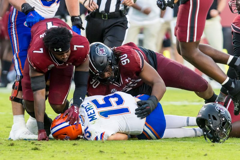 Oct 14, 2023; Columbia, South Carolina, USA; South Carolina Gamecocks defensive end Jordan Strachan (7) and South Carolina Gamecocks defensive tackle T.J. Sanders (90) get up after sacking Florida Gators quarterback Graham Mertz (15) in the second half at Williams-Brice Stadium. Mandatory Credit: Jeff Blake-USA TODAY Sports