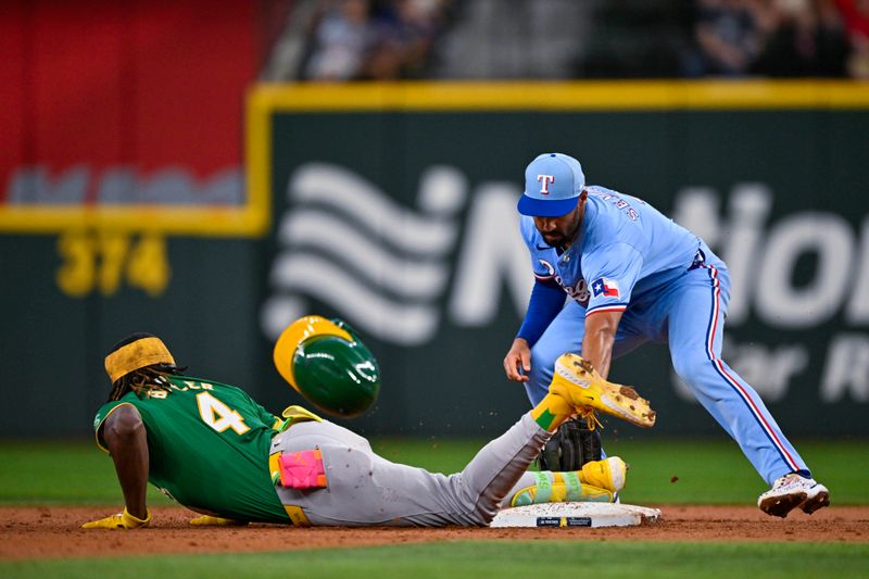 Sep 1, 2024; Arlington, Texas, USA; Oakland Athletics right fielder Lawrence Butler (4) slides past the tag of Texas Rangers second baseman Marcus Semien (2) during the third inning at Globe Life Field. Mandatory Credit: Jerome Miron-USA TODAY Sports