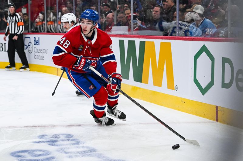 Jan 21, 2025; Montreal, Quebec, CAN; Montreal Canadiens defenseman Lane Hutson (48) plays the puck against the Tampa Bay Lightning during the second period at Bell Centre. Mandatory Credit: David Kirouac-Imagn Images