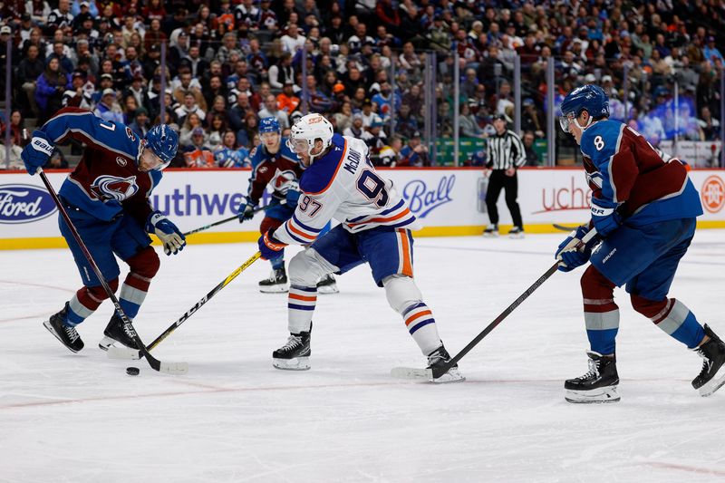 Jan 16, 2025; Denver, Colorado, USA; Edmonton Oilers center Connor McDavid (97) controls the puck against Colorado Avalanche defenseman Devon Toews (7) and defenseman Cale Makar (8) in the third period at Ball Arena. Mandatory Credit: Isaiah J. Downing-Imagn Images