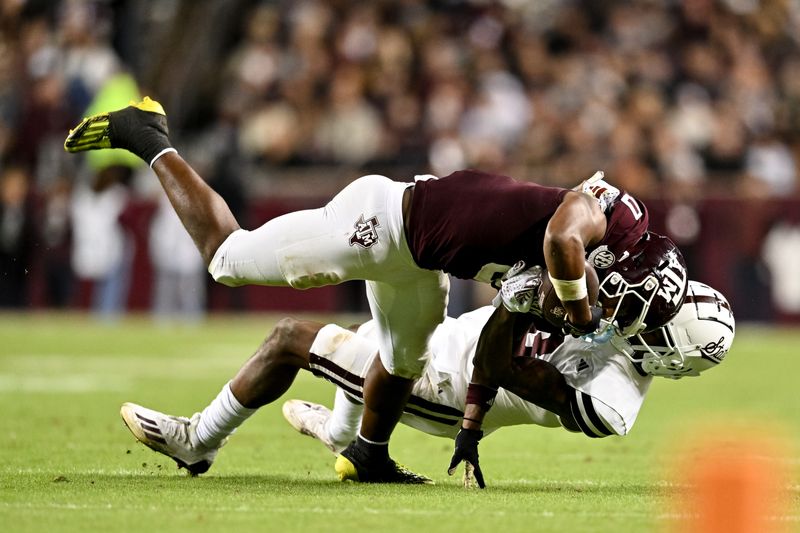 Nov 11, 2023; College Station, Texas, USA; Texas A&M Aggies wide receiver Ainias Smith (0) is tackled by Mississippi State Bulldogs cornerback Decamerion Richardson (3) during the second quarter at Kyle Field. Mandatory Credit: Maria Lysaker-USA TODAY Sports