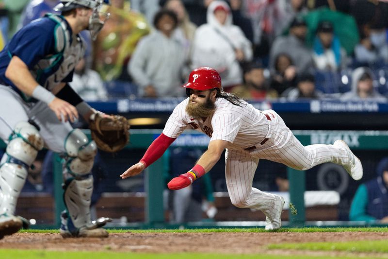 Apr 26, 2023; Philadelphia, Pennsylvania, USA; Philadelphia Phillies center fielder Brandon Marsh (16) slides into home plate past Seattle Mariners catcher Cal Raleigh (29) to score the go ahead run during the eighth inning at Citizens Bank Park. Mandatory Credit: Bill Streicher-USA TODAY Sports