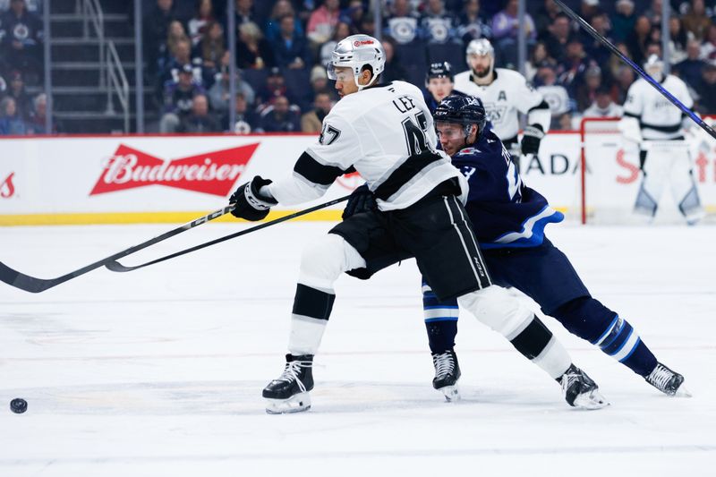 Jan 9, 2026; Winnipeg, Manitoba, CAN;  Los Angeles Kings forward Andre Lee (47) tries to skate away from Winnipeg Jets forward Danil Zhilkin (53) during the first period at Canada Life Centre. Mandatory Credit: Terrence Lee-Imagn Images
