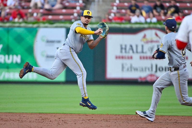 Aug 21, 2024; St. Louis, Missouri, USA;  Milwaukee Brewers shortstop Willy Adames (27) leaps and tosses the ball to second baseman Brice Turang (2) to force out St. Louis Cardinals third baseman Nolan Arenado (not pictured) during the second inning at Busch Stadium. Mandatory Credit: Jeff Curry-USA TODAY Sports