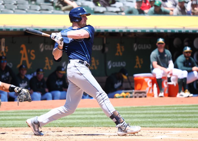 Jun 15, 2023; Oakland, California, USA; Tampa Bay Rays first baseman Luke Raley (55) hits a single against the Oakland Athletics during the second inning at Oakland-Alameda County Coliseum. Mandatory Credit: Kelley L Cox-USA TODAY Sports