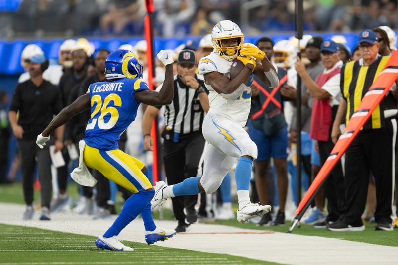 Los Angeles Chargers running back Joshua Kelley (25) runs with the ball past Los Angeles Rams safety Richard LeCounte III (26) during an NFL preseason football game, Saturday, Aug. 12, 2023, in Inglewood, Calif. (AP Photo/Kyusung Gong)