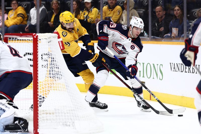 Oct 26, 2024; Nashville, Tennessee, USA; Nashville Predators left wing Filip Forsberg (9) fights Columbus Blue Jackets center Adam Fantilli (19) for the puck behind the net in the first period at Bridgestone Arena. Mandatory Credit: Casey Gower-Imagn Images