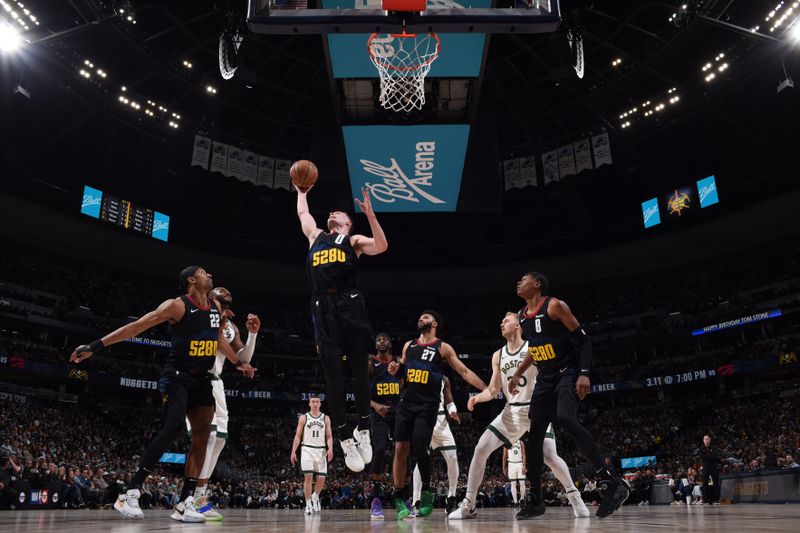 DENVER, CO - MARCH 7: Christian Braun #0 of the Denver Nuggets grabs a rebound during the game against the Boston Celtics on March 7, 2024 at the Ball Arena in Denver, Colorado. NOTE TO USER: User expressly acknowledges and agrees that, by downloading and/or using this Photograph, user is consenting to the terms and conditions of the Getty Images License Agreement. Mandatory Copyright Notice: Copyright 2024 NBAE (Photo by Garrett Ellwood/NBAE via Getty Images)