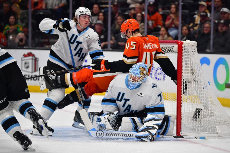 Dec 3, 2025; Anaheim, California, USA; Utah Mammoth center Logan Cooley (92) hits Anaheim Ducks right wing Beckett Sennecke (45) onto goaltender Karel Vejmelka (70) during the first period at Honda Center. Mandatory Credit: Gary A. Vasquez-Imagn Images