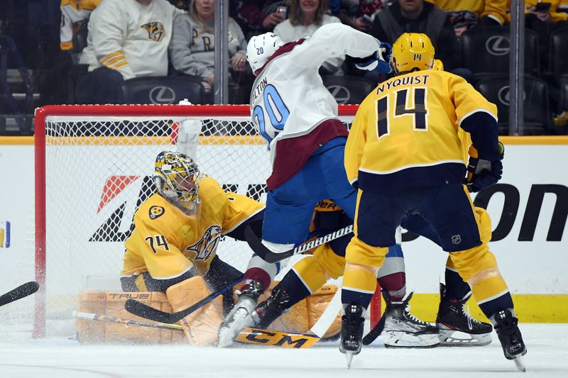 Mar 2, 2024; Nashville, Tennessee, USA; Nashville Predators goaltender Juuse Saros (74) makes a save against Colorado Avalanche center Ross Colton (20) during the first period at Bridgestone Arena. Mandatory Credit: Christopher Hanewinckel-USA TODAY Sports