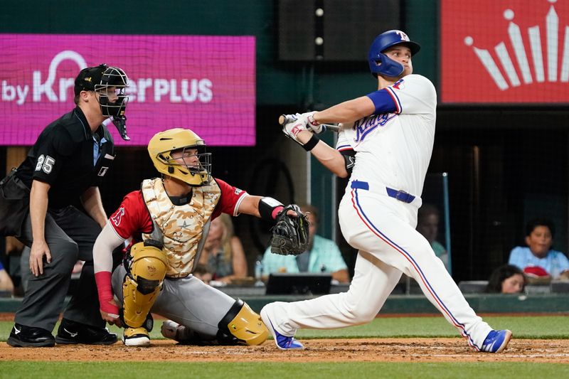 May 18, 2024; Arlington, Texas, USA; Texas Rangers shortstop Corey Seager (5) hits a single during the third inning against the Los Angeles Angels at Globe Life Field. Mandatory Credit: Raymond Carlin III-USA TODAY Sports