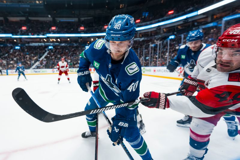 Mar 4, 2026; Vancouver, British Columbia, CAN; Vancouver Canucks forward Elias Pettersson (40) battles with Carolina Hurricanes forward Jordan Martinook (48) in the first at Rogers Arena. Mandatory Credit: Bob Frid-Imagn Images