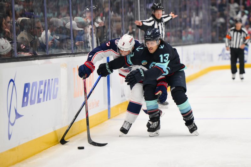 Nov 12, 2024; Seattle, Washington, USA; Columbus Blue Jackets defenseman Jack Johnson (3) and Seattle Kraken left wing Brandon Tanev (13) play the puck during the second period at Climate Pledge Arena. Mandatory Credit: Steven Bisig-Imagn Images