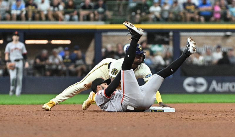 Aug 28, 2024; Milwaukee, Wisconsin, USA; Milwaukee Brewers third base Andruw Monasterio (14) slides safely into second base ahead of the tag of San Francisco Giants second base Thairo Estrada (39) in the fifth inning at American Family Field. Mandatory Credit: Michael McLoone-USA TODAY Sports