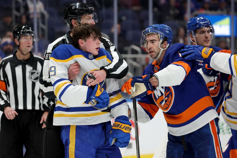 Nov 30, 2024; Elmont, New York, USA; Buffalo Sabres left wing Zach Benson (9) is separated from New York Islanders center Kyle Palmieri (21) by linesman Ryan Daisy (81) during the third period at UBS Arena. Mandatory Credit: Brad Penner-Imagn Images