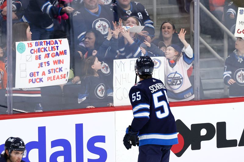 Feb 25, 2024; Winnipeg, Manitoba, CAN; Winnipeg Jets center Mark Scheifele (55) tosses a puck to fans before a game against the Arizona Coyotes at Canada Life Centre. Mandatory Credit: James Carey Lauder-USA TODAY Sports