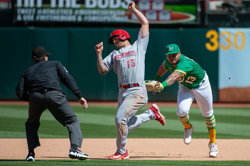 Apr 29, 2023; Oakland, California, USA; Oakland Athletics second baseman Jordan Diaz (13) tags out Cincinnati Reds center fielder Nick Senzel (15) during the seventh inning at RingCentral Coliseum. Mandatory Credit: Ed Szczepanski-USA TODAY Sports