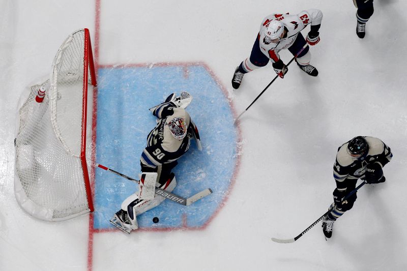 Dec 21, 2023; Columbus, Ohio, USA; Columbus Blue Jackets goalie Elvis Merzlikins (90) makes a stick save as Washington Capitals right wing Tom Wilson (43) looks for a rebound during the second period at Nationwide Arena. Mandatory Credit: Russell LaBounty-USA TODAY Sports