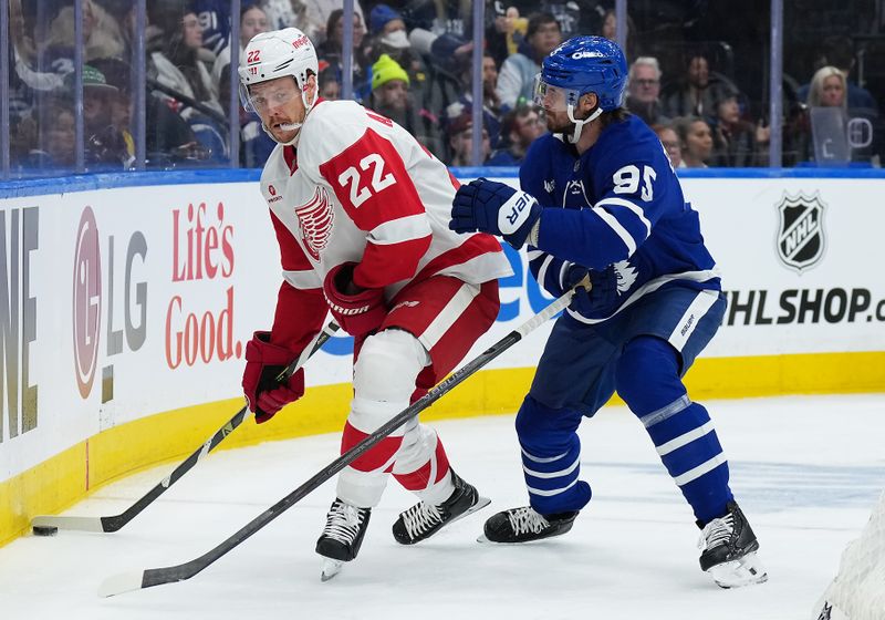 Oct 2, 2025; Toronto, Ontario, CAN; Detroit Red Wings defenseman Shai Buium (22) battles for the puck with Toronto Maple Leafs defenseman Oliver Ekman-Larsson (95) during the second period at Scotiabank Arena. Mandatory Credit: Nick Turchiaro-Imagn Images