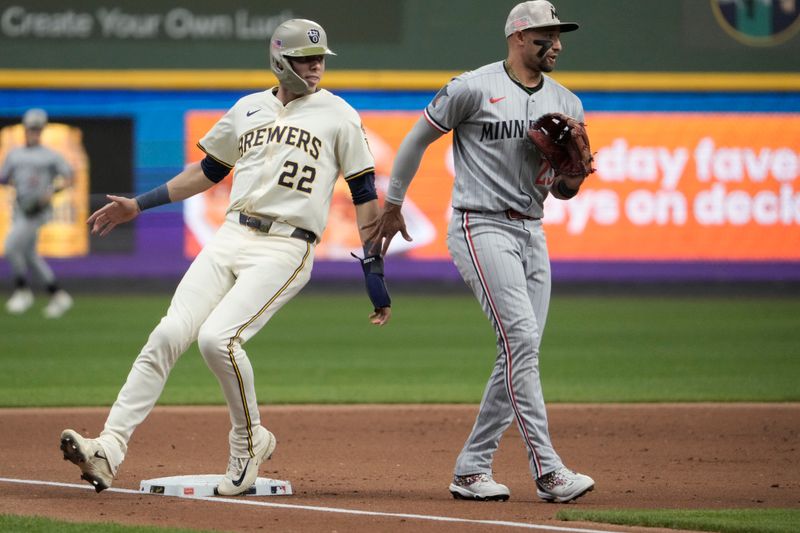 May 18, 2025; Milwaukee, Wisconsin, USA; Milwaukee Brewers outfielder Christian Yelich (22) holds up on third base against Minnesota Twins third base Royce Lewis (23) in the second inning at American Family Field. Mandatory Credit: Michael McLoone-Imagn Images