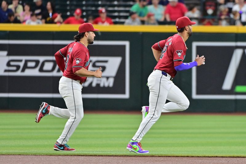 May 15, 2024; Phoenix, Arizona, USA; Arizona Diamondbacks outfielder Lourdes Gurriel Jr. (12) and third base Eugenio Suárez (28) warm up prior to the game against the Cincinnati Reds at Chase Field. Mandatory Credit: Matt Kartozian-USA TODAY Sports