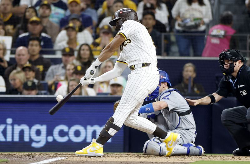 Oct 9, 2024; San Diego, California, USA; San Diego Padres outfielder Fernando Tatis Jr. (23) hits a double in the third inning against the Los Angeles Dodgers during game four of the NLDS for the 2024 MLB Playoffs at Petco Park.  Mandatory Credit: Denis Poroy-Imagn Images
