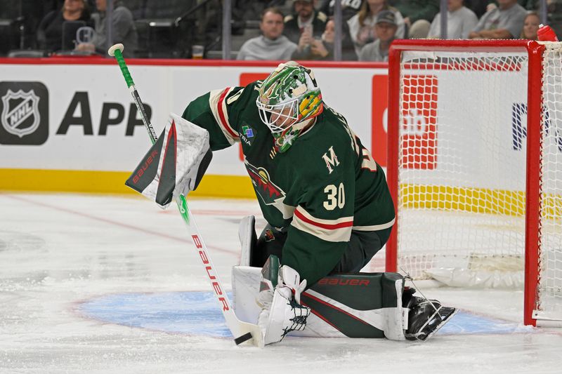 Sep 29, 2024; Saint Paul, Minnesota, USA;  Minnesota Wild goalie Jesper Wallstedt (30) controls the puck against the Dallas Stars during the first period at Xcel Energy Center. Mandatory Credit: Nick Wosika-Imagn Images