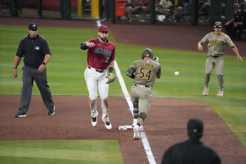Aug 6, 2025; Phoenix, Arizona, USA; San Diego Padres catcher Freddy Fermin (54) reaches first base safely as a throw gets away from Arizona Diamondbacks first base Tyler Locklear (28) during the eighth inning at Chase Field. Mandatory Credit: Joe Camporeale-Imagn Images