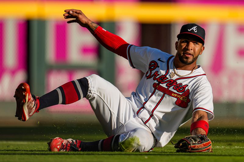 Oct 1, 2023; Cumberland, Georgia, USA; Atlanta Braves left fielder Eddie Rosario (8) makes a sliding catch on a ball hit by Washington Nationals shortstop CJ Abrams (5) (not shown) during the eighth inning at Truist Park. Mandatory Credit: Dale Zanine-USA TODAY Sports