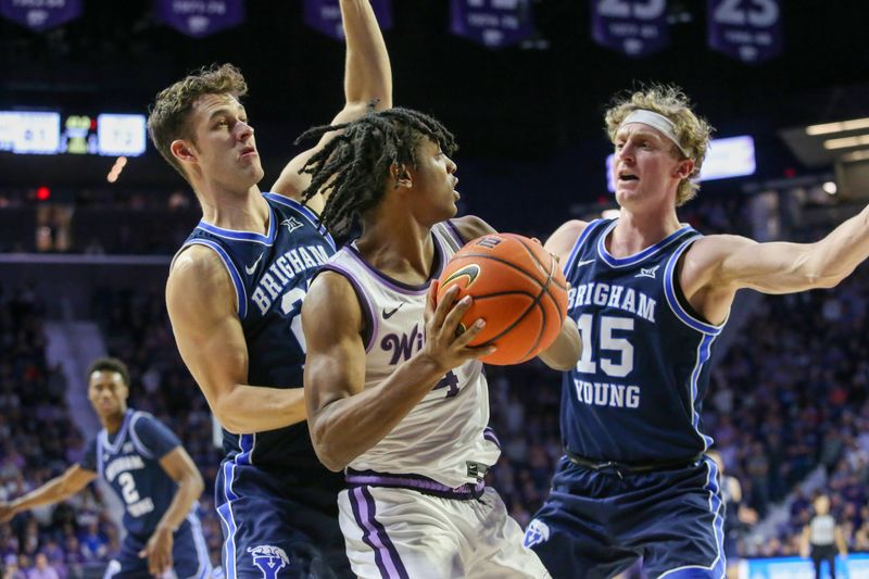 Feb 24, 2024; Manhattan, Kansas, USA; Kansas State Wildcats guard Dai Dai Ames (4) is guarded by Brigham Young Cougars guards Richie Saunders (15) and Trevin Knell (21) during the second half at Bramlage Coliseum. Mandatory Credit: Scott Sewell-USA TODAY Sports