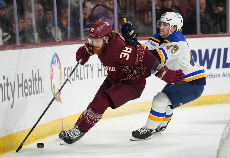 Dec 2, 2023; Tempe, Arizona, USA; St. Louis Blues defenseman Scott Perunovich (48) checks Arizona Coyotes center Liam O'Brien (38) during the second period at Mullett Arena. Mandatory Credit: Joe Camporeale-USA TODAY Sports